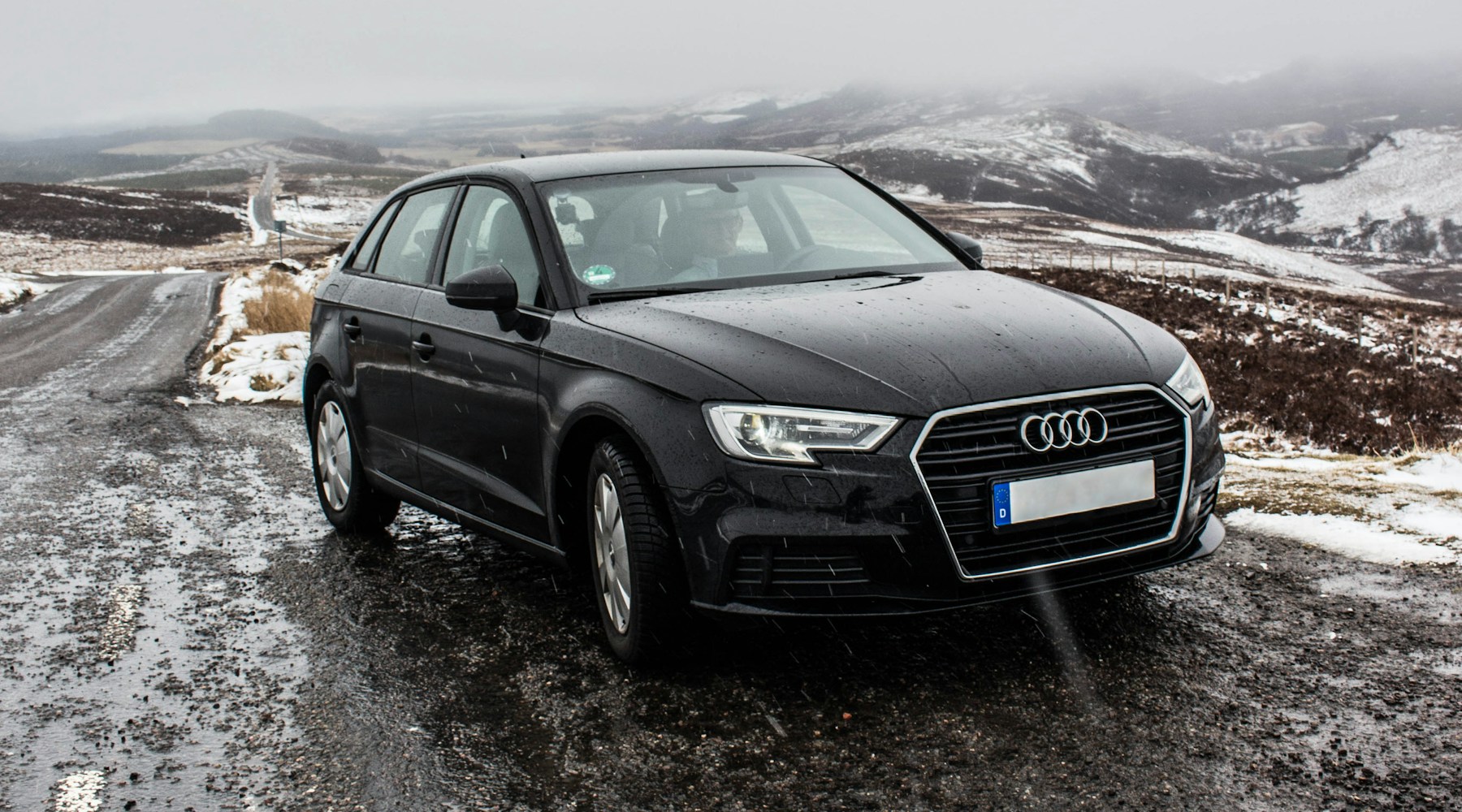 Black Audi on a quiet winter road